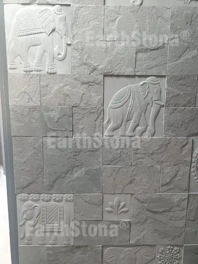 Hand carved elephant motif natural stone wall cladding panel installed on luxury bungalow entrance foyer wall